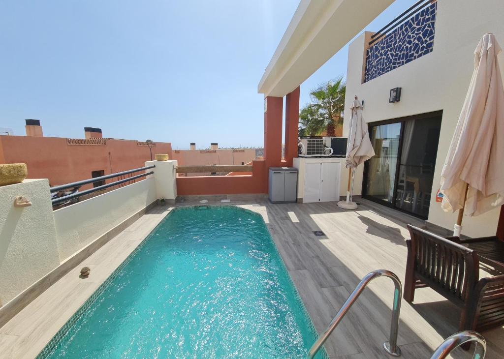 a swimming pool on the roof of a house at Tirreno Vacances in San Juan de los Terreros