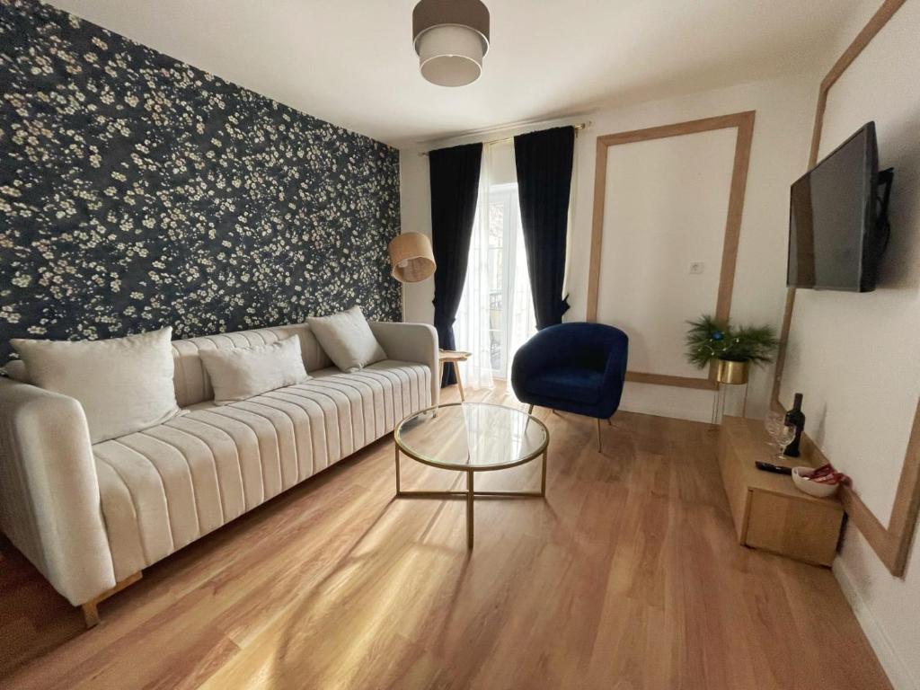 sala de estar con sofá blanco y mesa de cristal en Lungomare Apartments, en Petrovac na Moru