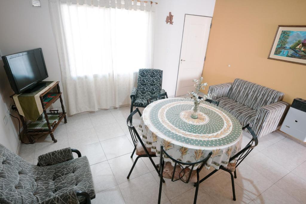een woonkamer met een tafel en stoelen en een televisie bij Departamento San Rafael in San Rafael