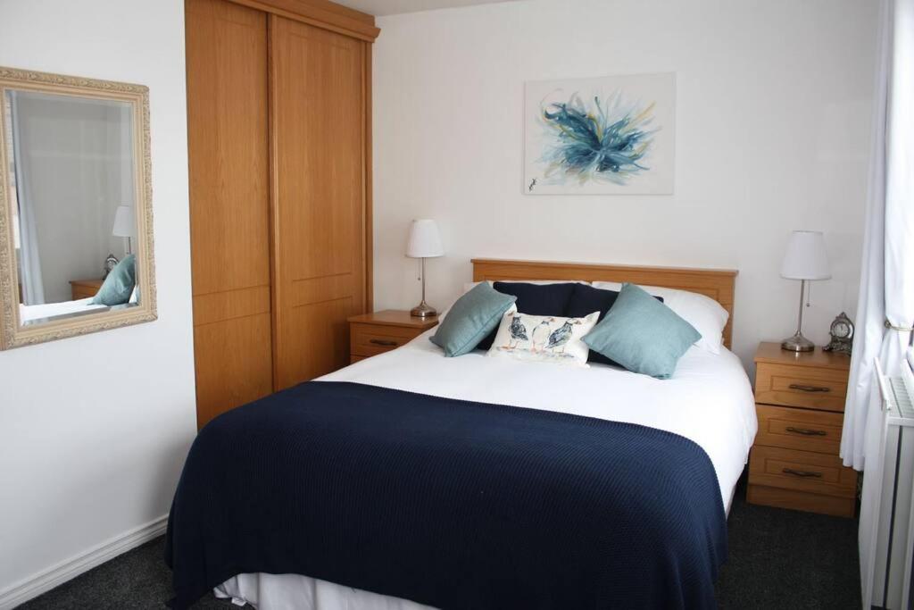 een slaapkamer met een bed en een spiegel bij Harbour View House in Ballycastle