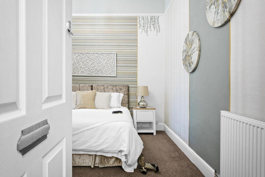 a bedroom with a bed and a clock on the wall at Kethla House in Torquay