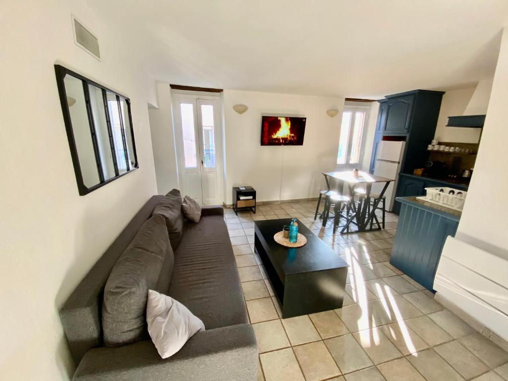 a living room with a couch and a table at T2 rue piétonne Le Lavandou climatisé in Le Lavandou