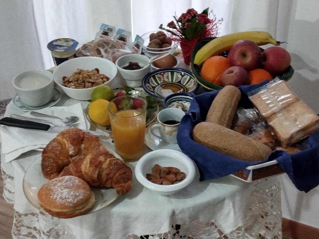 un tavolo per la colazione con pane e altri prodotti per la colazione di Locazione Turistica Conca d'Oro a Crispiano