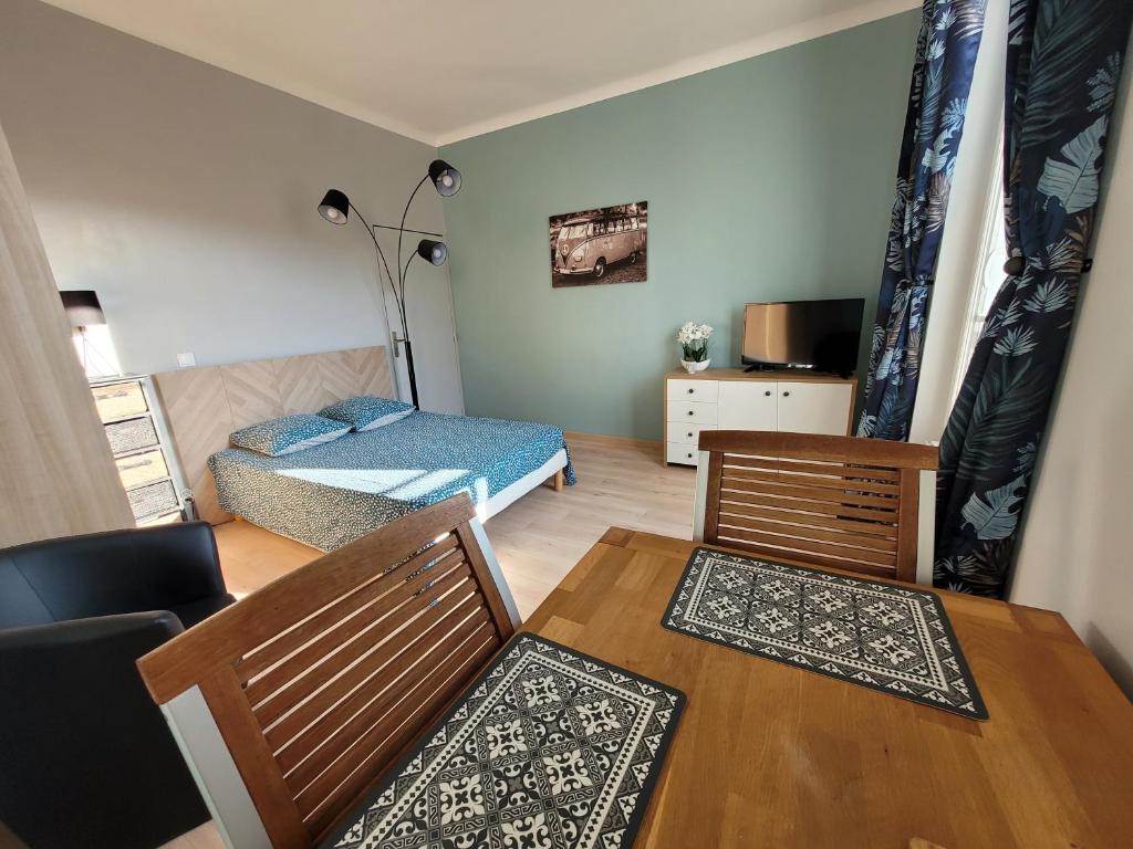 1 dormitorio y sala de estar con mesa y sillas. en Appartement meublé rénové idéal pour curistes ou vacanciers, en La Roche-Posay