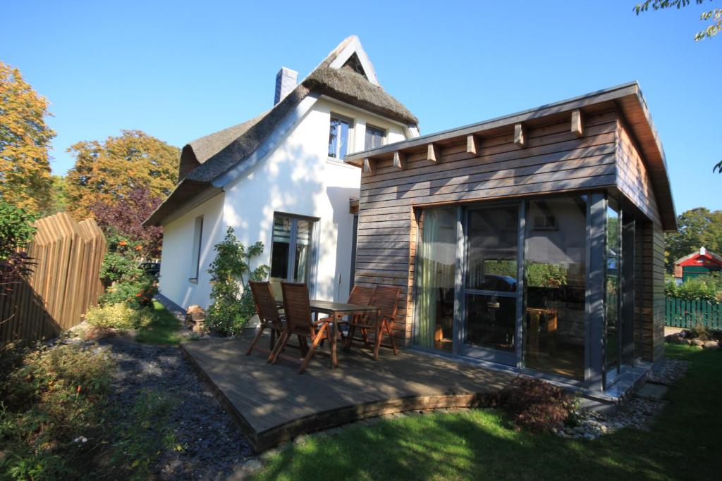 een klein huisje met een tafel en stoelen op een terras bij Casa Manfredi in Prerow