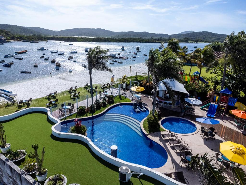 uma vista aérea de um resort com uma piscina e uma praia em Hotel Paradiso del Sol em Cabo Frio