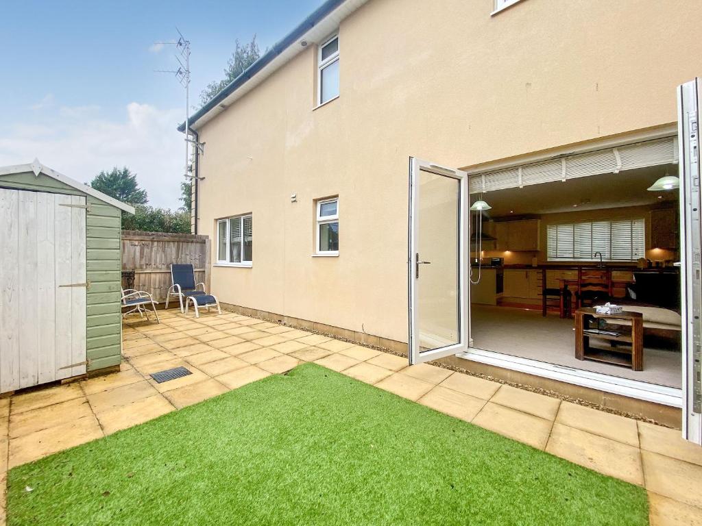 een patio met een gazon en een huis bij Peacock Court in Corsham