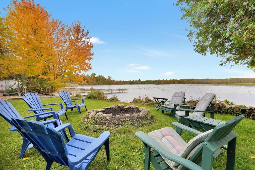 eine Gruppe von Gartenstühlen neben einem See in der Unterkunft Rustic cottage on Canal Lake in Carden