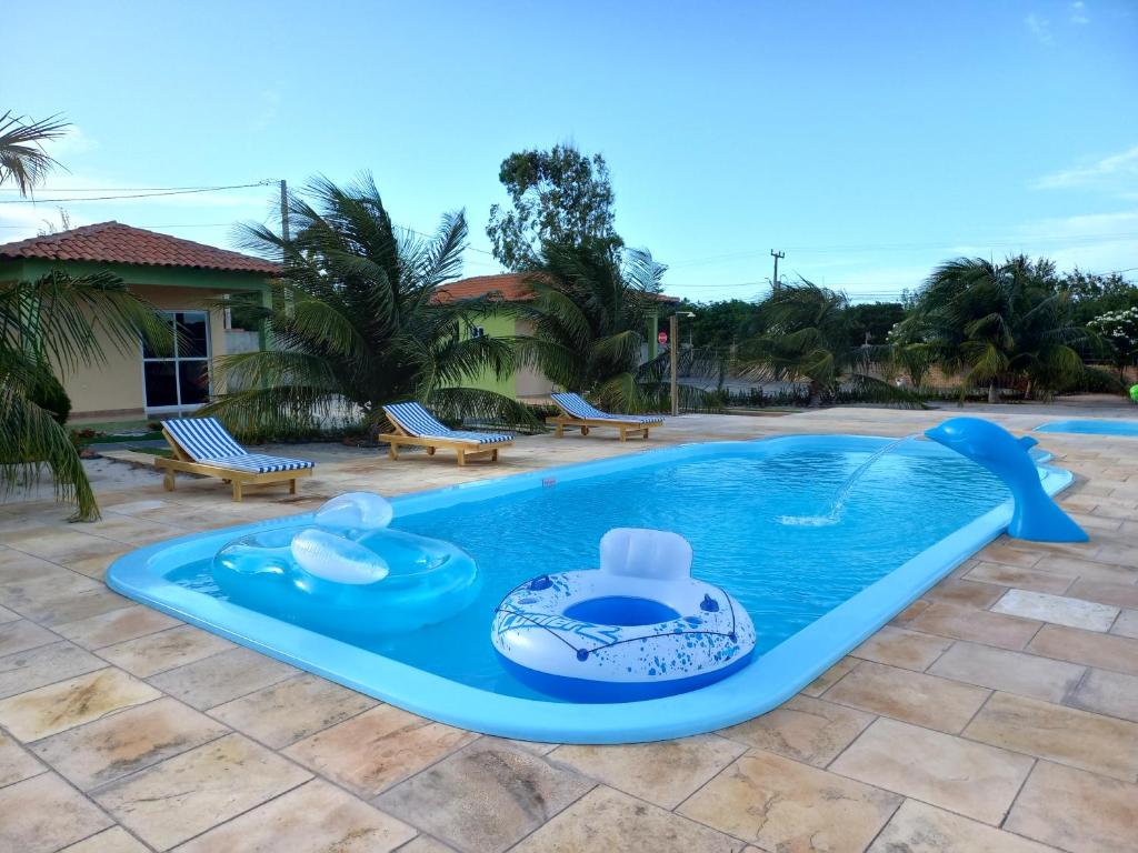 una piscina con due sedie e una piscina di Chalés Canoa Beach a Barra Grande