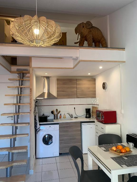 a small kitchen with a staircase leading up to a tiny house at Duplex Raphael- Wi-fi et parking privé in Toulon