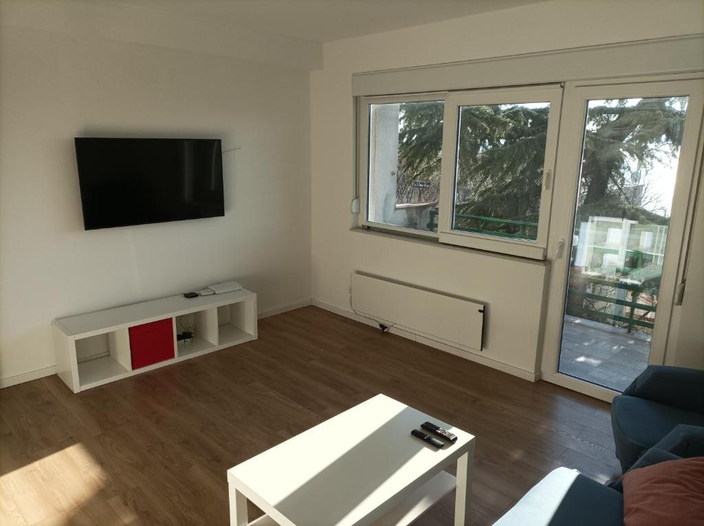 a living room with a couch and a tv at Apartman Pećine in Rijeka