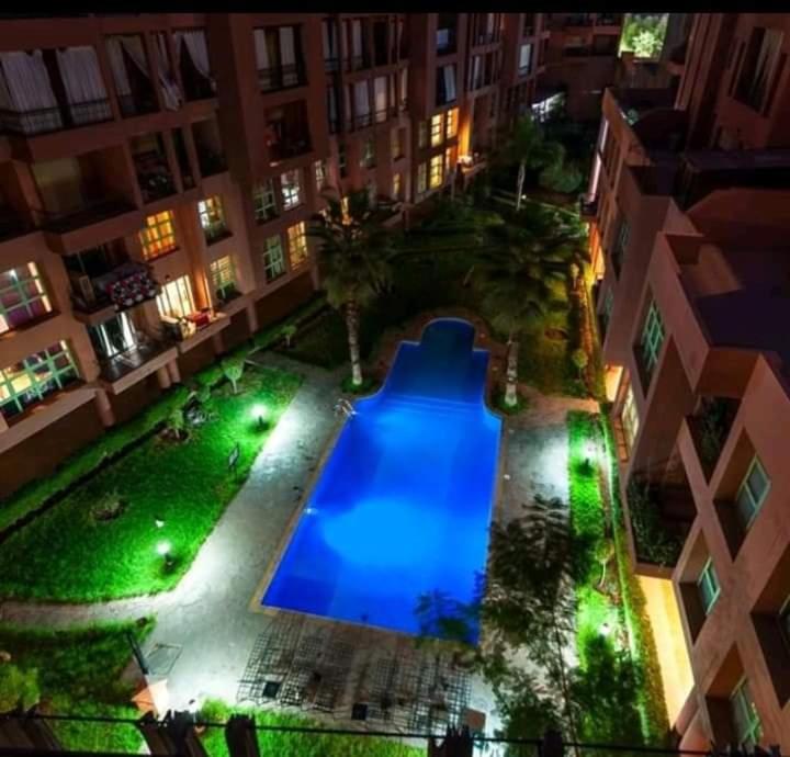 Propre appartement à loué pour les familles في مراكش: اطلالة علوية على مسبح في مبنى في الليل
