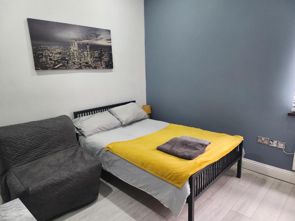 a bedroom with a bed with a yellow blanket at Dodi Apartment in London
