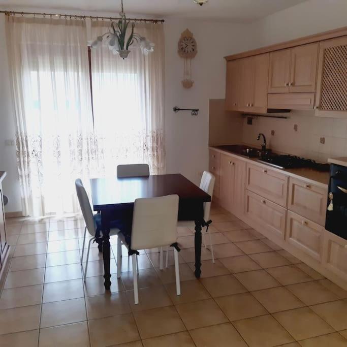 a kitchen with a table and chairs in a room at appartamento dei pioppi in Pescara
