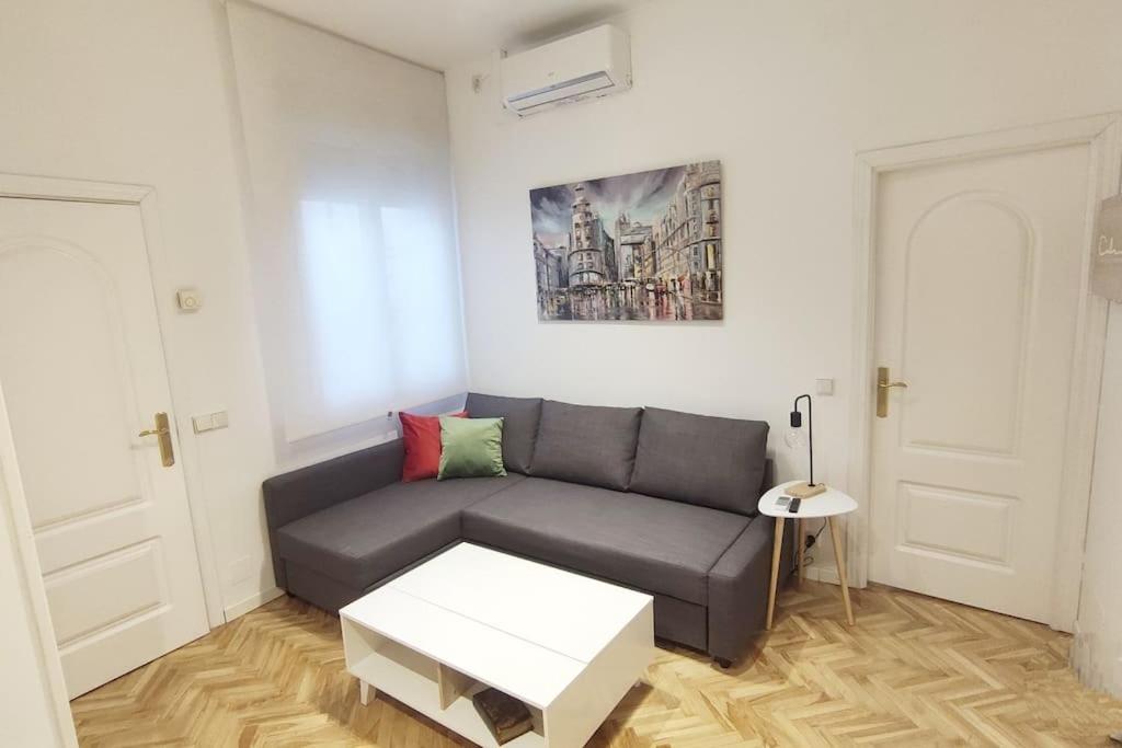 un soggiorno con divano e tavolo di Lovely apartment in Madrid center (Chueca) a Madrid