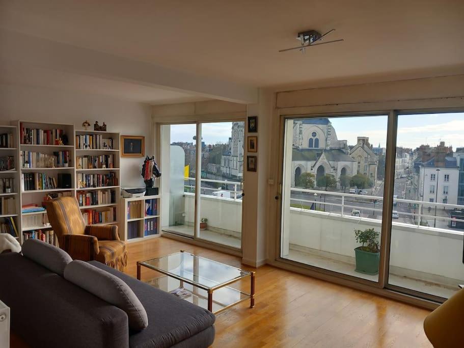ein Wohnzimmer mit einem Sofa und Stadtblick in der Unterkunft Bel appartement lumineux en centre-ville in Orléans