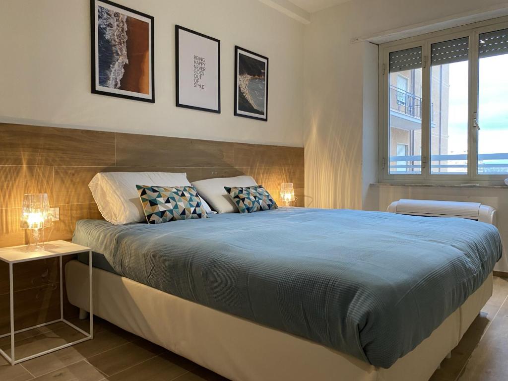 a bedroom with a large bed and two windows at Colombo 1935 - Apartments in Follonica