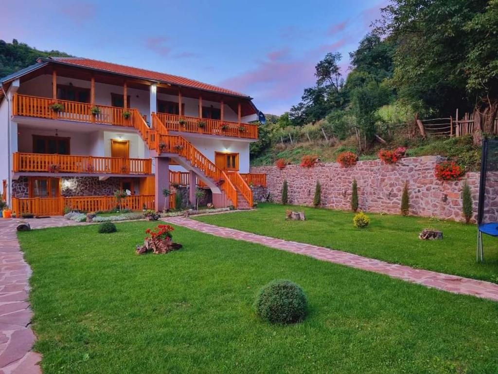 ein großes Haus mit Rasen und Treppe in der Unterkunft Kuca Stojanovica Topli Do in Pirot