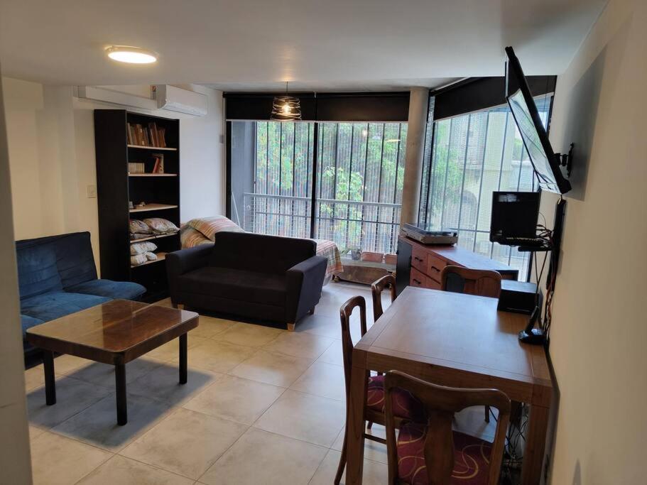 a living room with a couch and a table at Departamento Loft Pichincha in Rosario