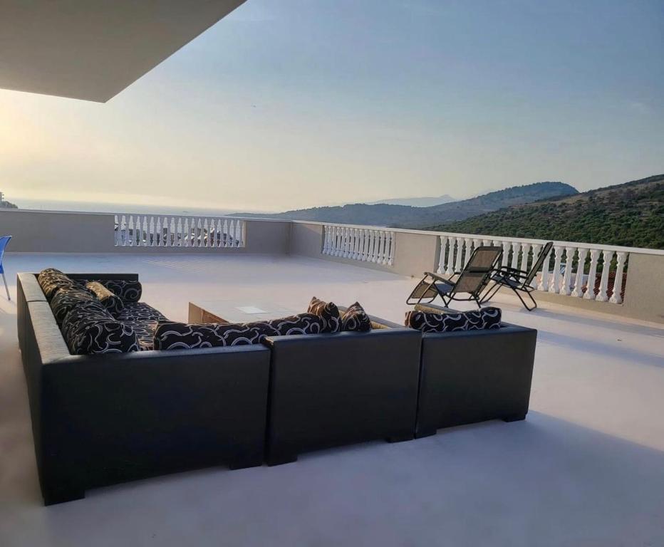 eine Couch mit zwei Hunden, die auf einem Balkon liegen in der Unterkunft Vila Chelsea in Ksamil