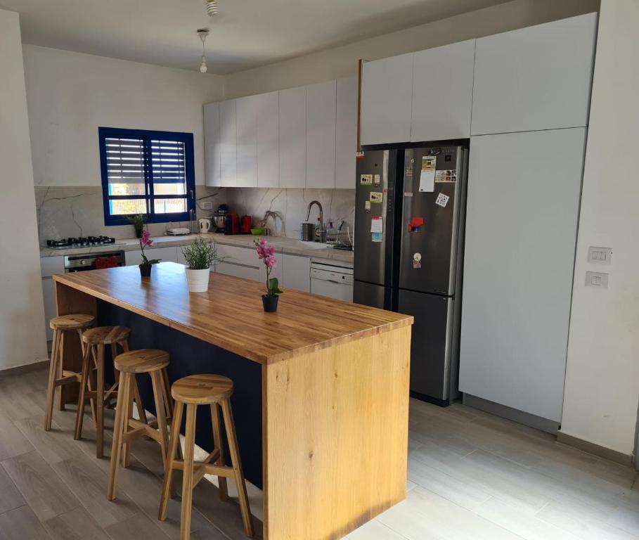 a kitchen with a large wooden island with bar stools at Yvonne's Home Sde Boker in Midreshet Ben Gurion