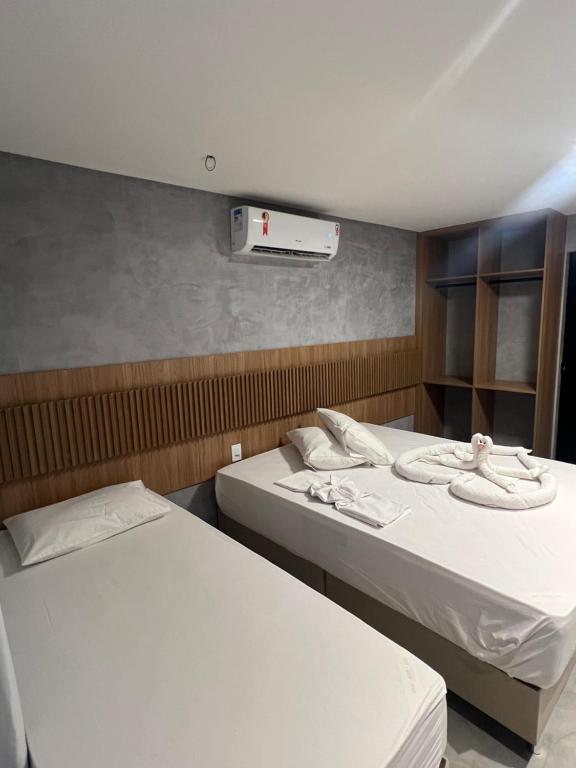 a room with two beds and a air conditioner at MarBello in Maragogi