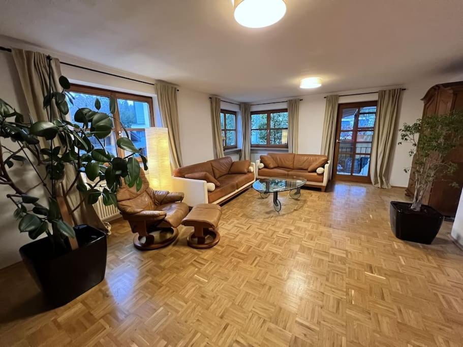 a living room with couches and a table at Garten-Ferienwohnung Seppi in Tutzing