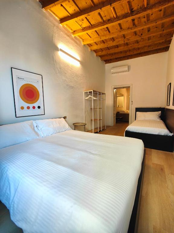 a bedroom with two white beds and a wooden ceiling at Crocetta Charme Apartment in Milan