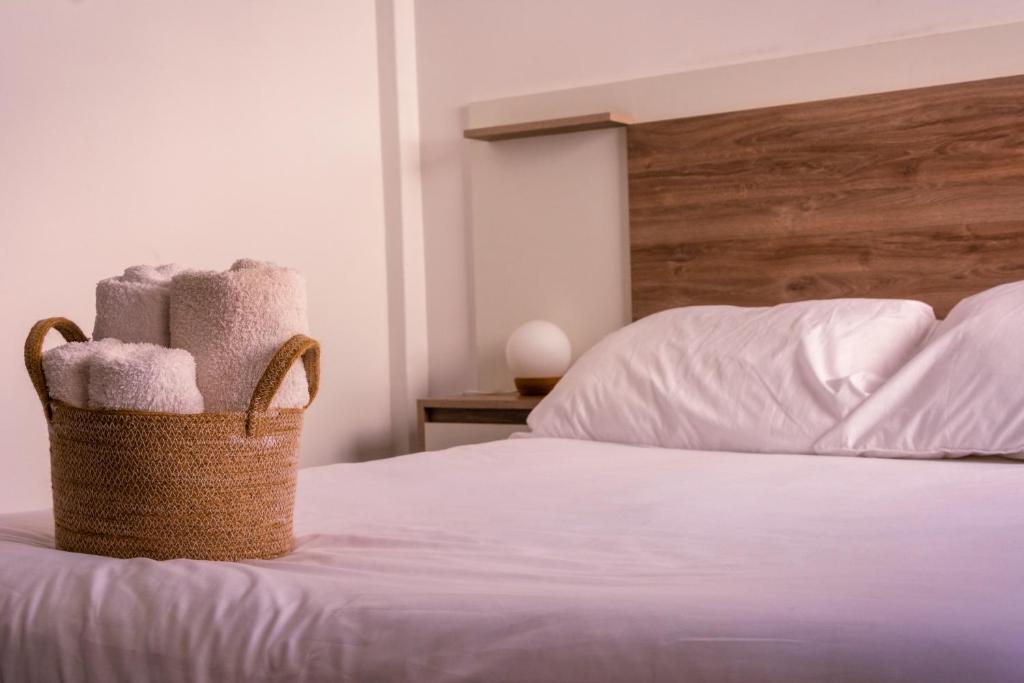 una cesta de toallas encima de la cama en undiano apart en Bahía Blanca