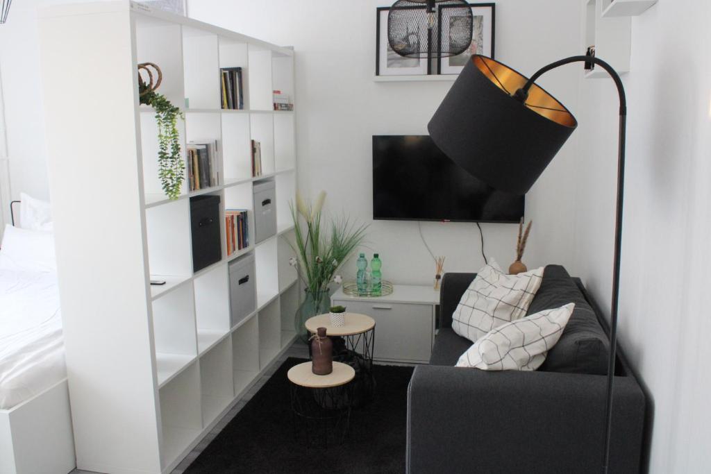 - un salon avec un canapé et une télévision dans l'établissement Schickes Appartement an der Neckarpromenade, à Heilbronn