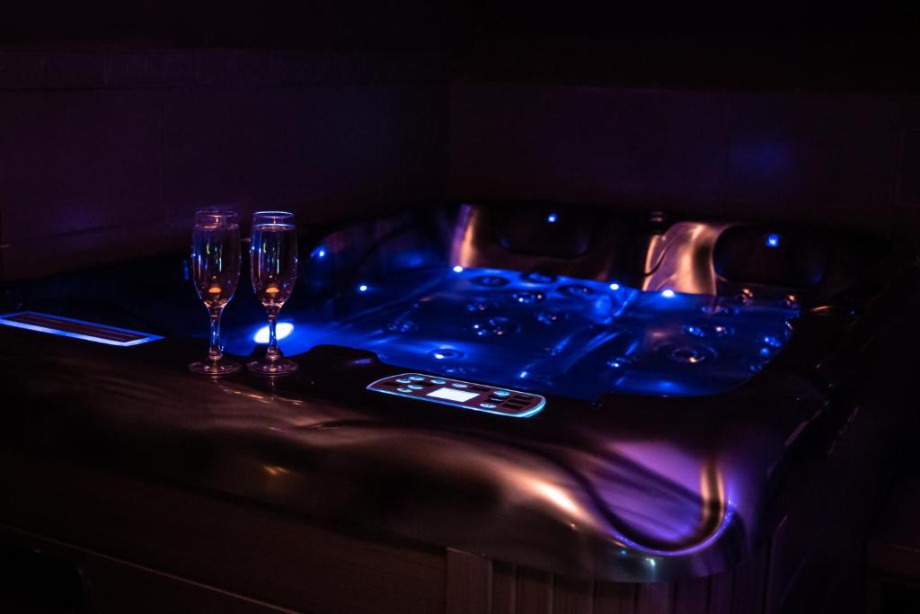 a table with two wine glasses on a table with a tableablish at PAUSE NATURE SORBAIS Chambre avec SPA, SAUNA, HAMMAM SHOWER, STREAMING et arrivée autonome in Sorbais