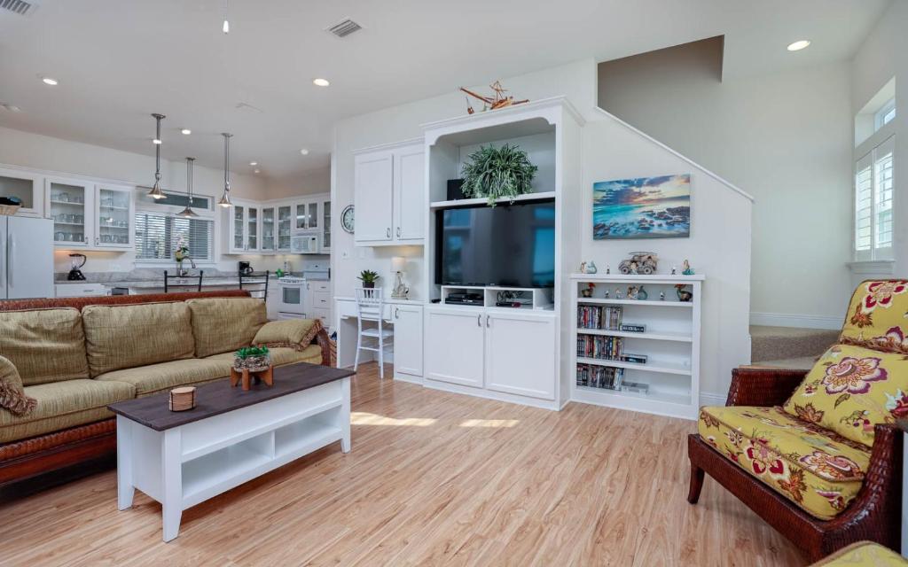 Una sala de estar con un sofá, un televisor y una mesa. en Pelican Roost 9407 home, en Gulf Highlands