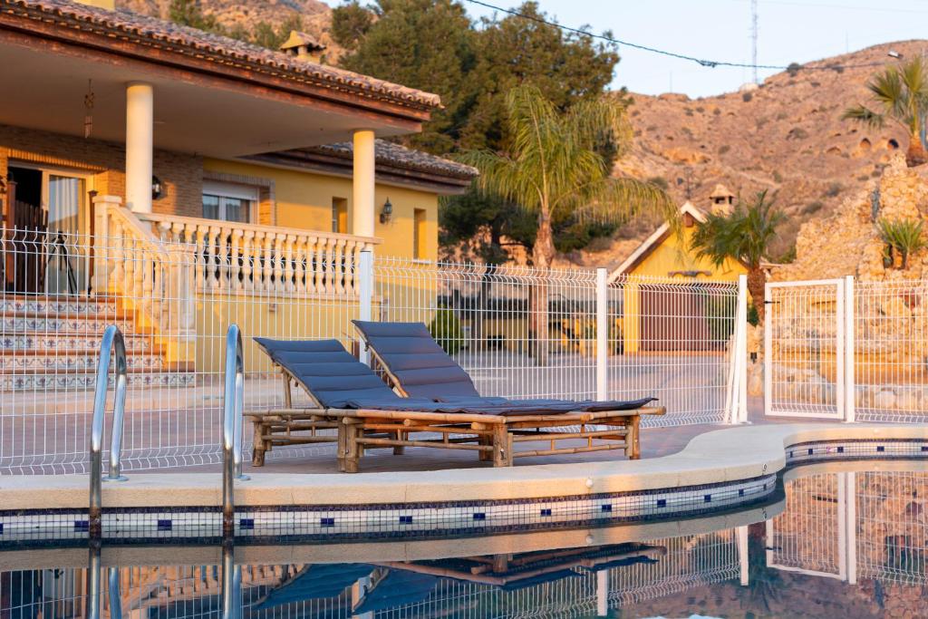 um grupo de cadeiras sentadas ao lado de uma piscina em Casa Rural Familiar Piscina Sierra Balumba em Cobatillas