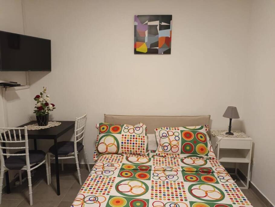 Habitación pequeña con cama y mesa con sillas. en Chambre américaine à Angondjé en Libreville