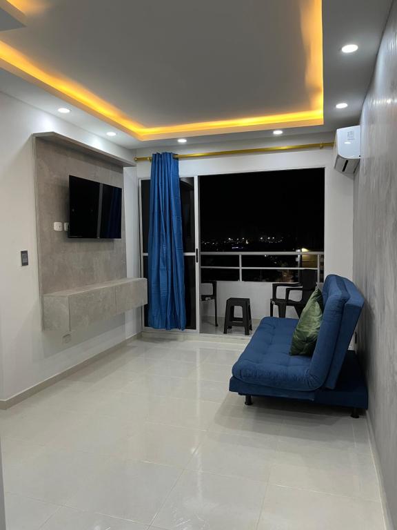 卡塔赫纳Confortable apartamento cerca al mar y centro histórico的客厅里有一张蓝色沙发和一台电视