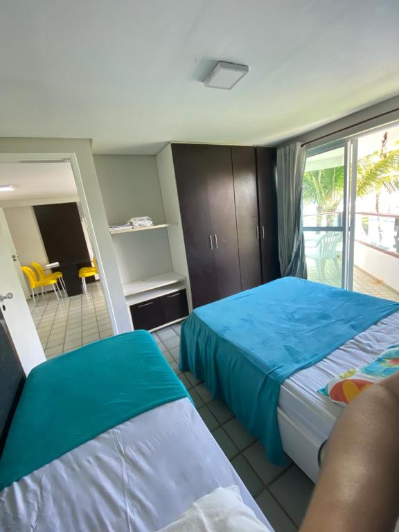 a bedroom with two beds and a balcony at Ancorar Flat in Porto De Galinhas