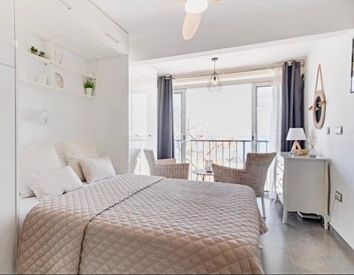 a white bedroom with a bed and a balcony at Apartamento Loft-Suite in Platja d'Aro