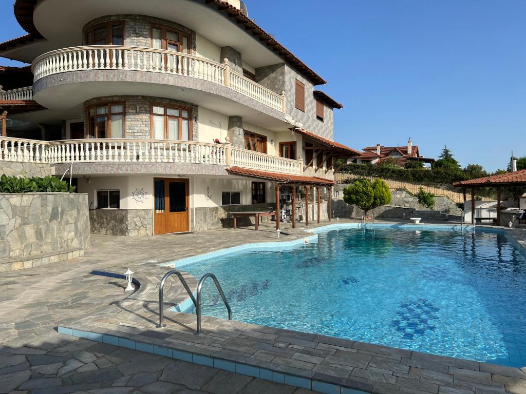 un hotel con piscina frente a un edificio en El Paraiso Premium, en Tesalónica