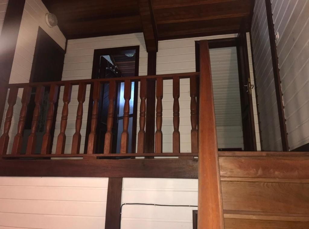 - un escalier en bois dans une maison avec fenêtre dans l'établissement Montabo duplex, à Cayenne