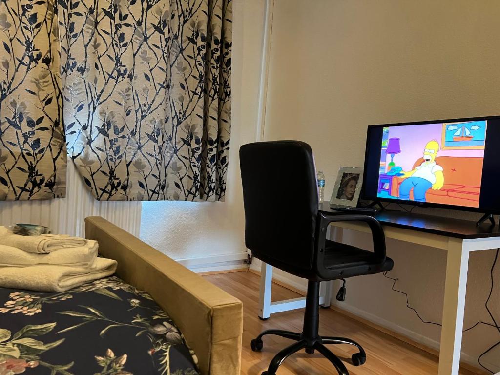 a room with a desk with a computer and a chair at Park View Serviced Apartment - Next to Northolt Tube Station - Near Central London & Wembley in Northolt