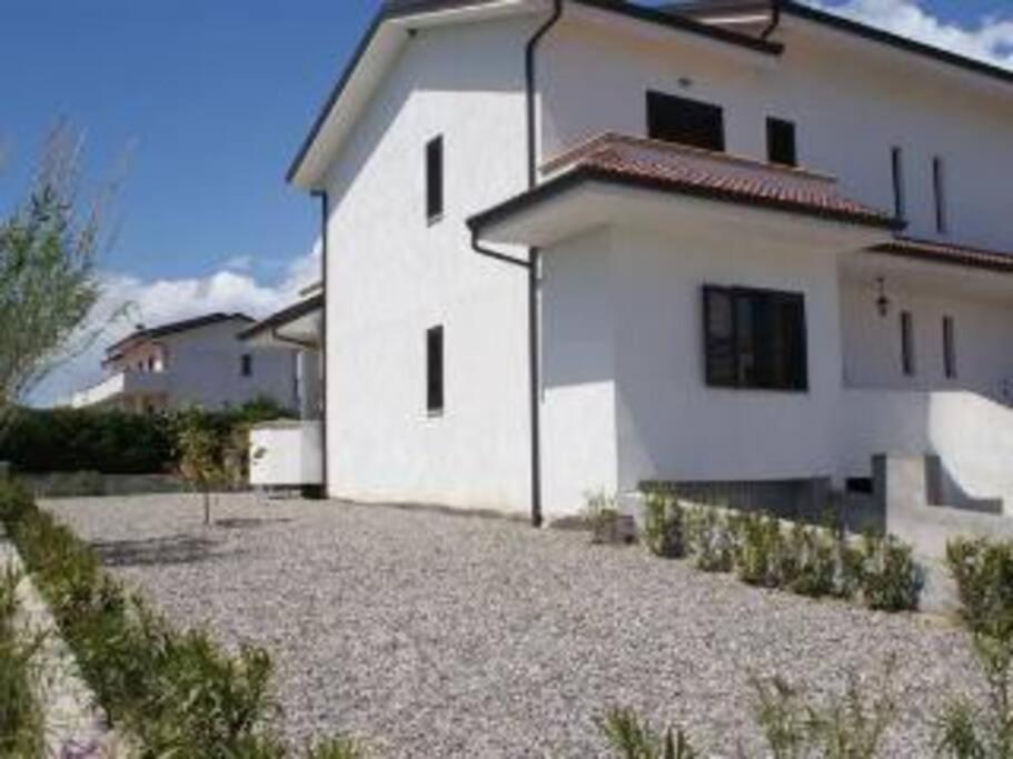 a white house with a gravel driveway in front of it at Stignano Mare, near Caulonia, Calabria, Italy in Focà