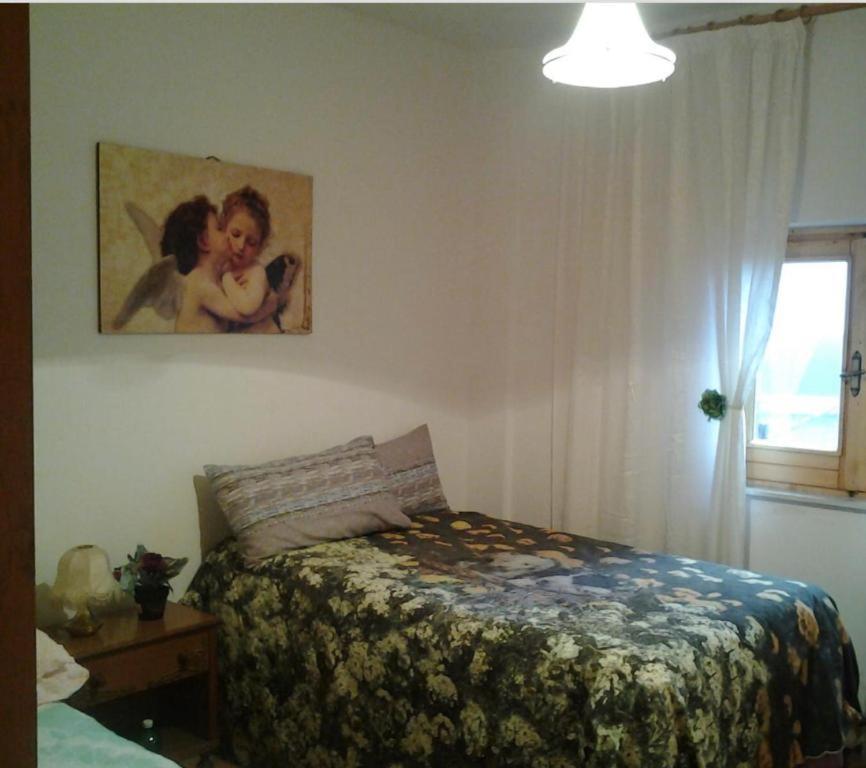 ein Schlafzimmer mit einem Bett und einem Bild an der Wand in der Unterkunft Monte Livata Sky 1 in Subiaco