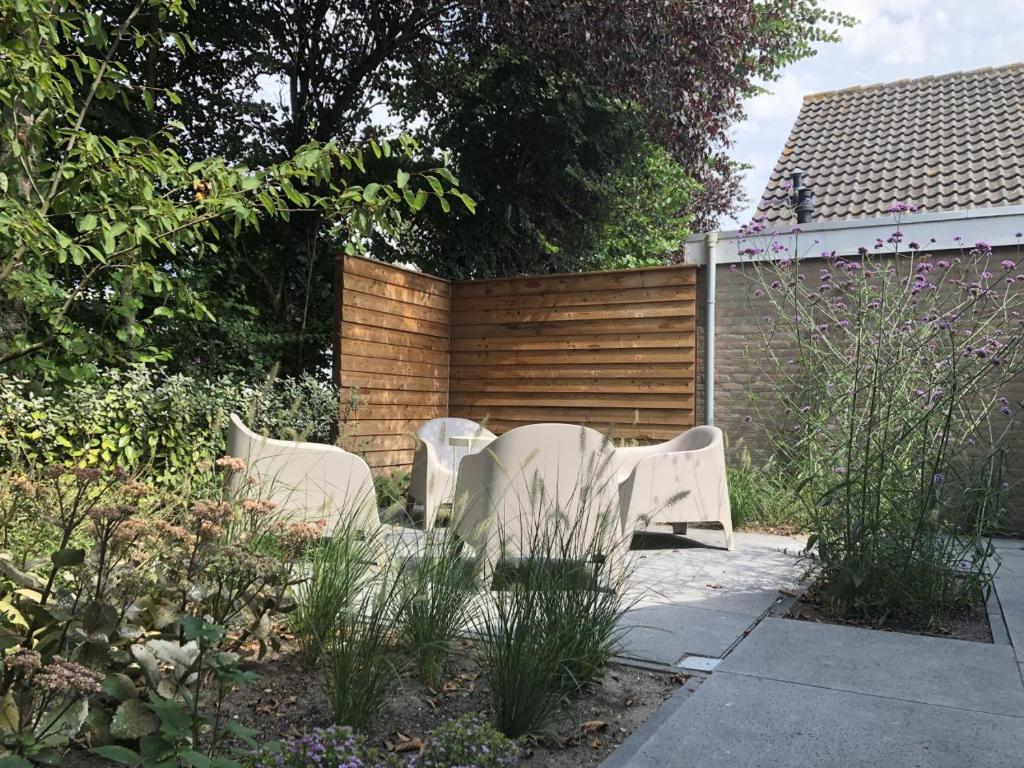 twee witte stoelen in de tuin bij Saint Palais- Sincfal 26 in Cadzand