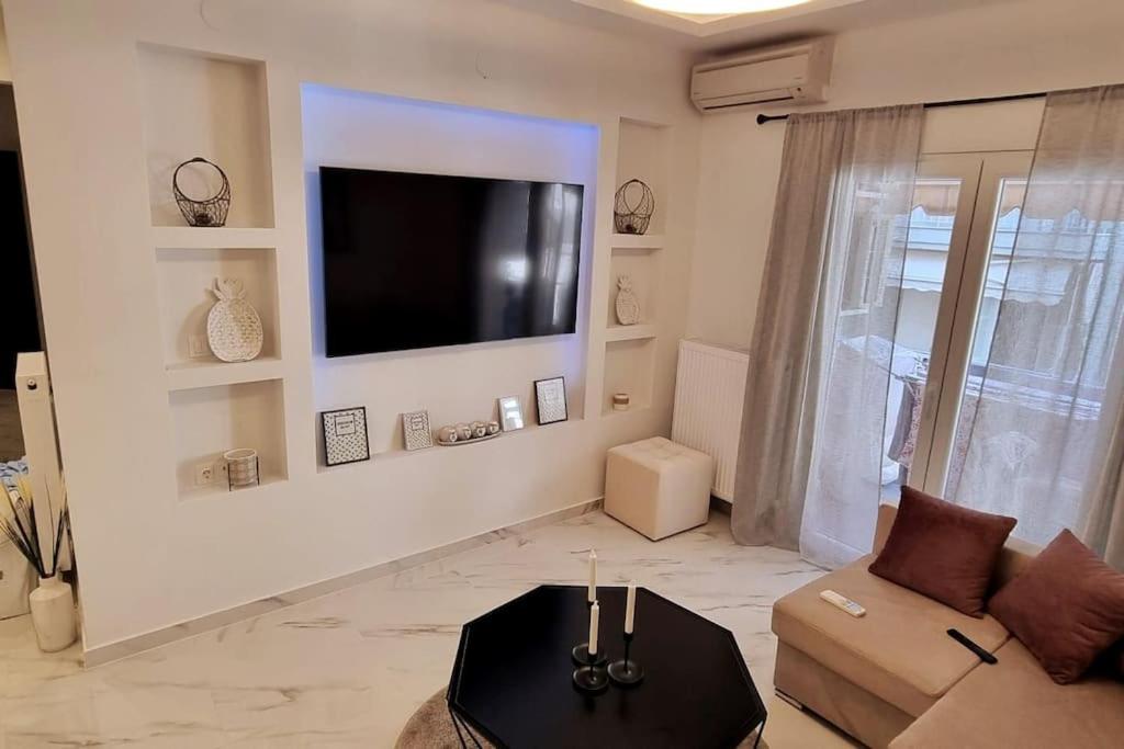 uma sala de estar com uma televisão de ecrã plano na parede em Luxurious Apartment in the Heart of Thessaloniki em Tessalônica