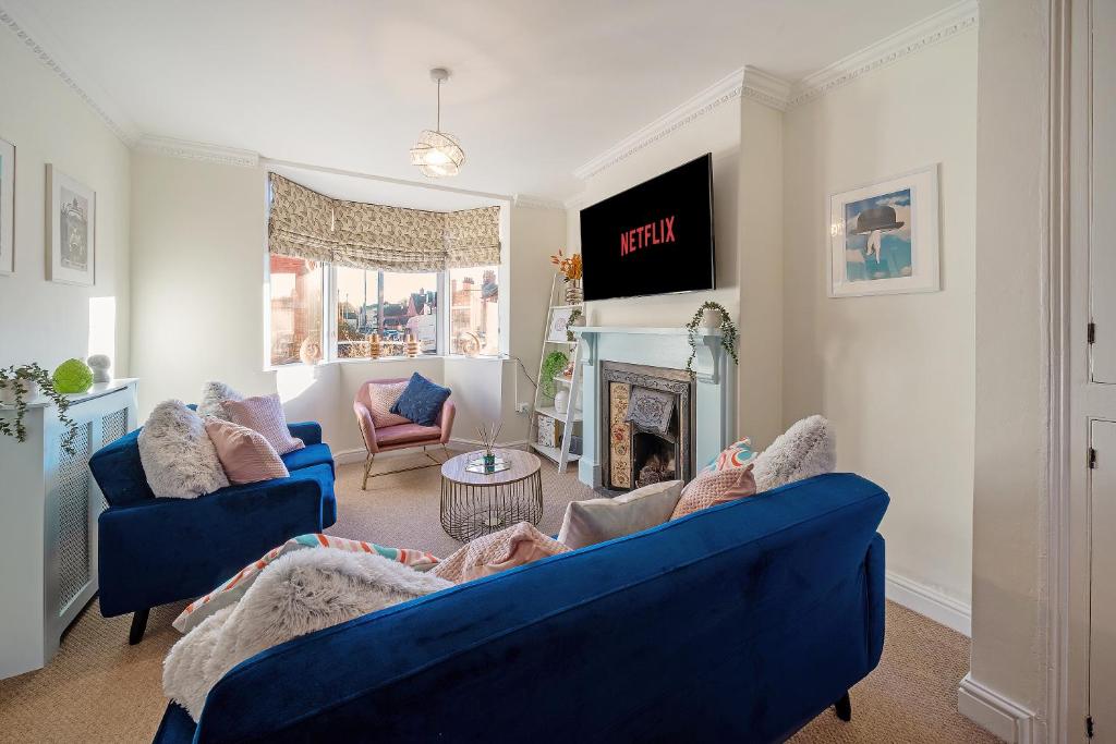 sala de estar con 2 sofás azules y chimenea en Spacious home with garden Heart of the town WiFi Smart TV en Cirencester