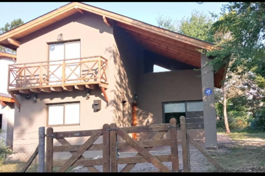 una casa con una valla de madera delante de ella en Hospedaje ideal a metros del rio en Los Reartes