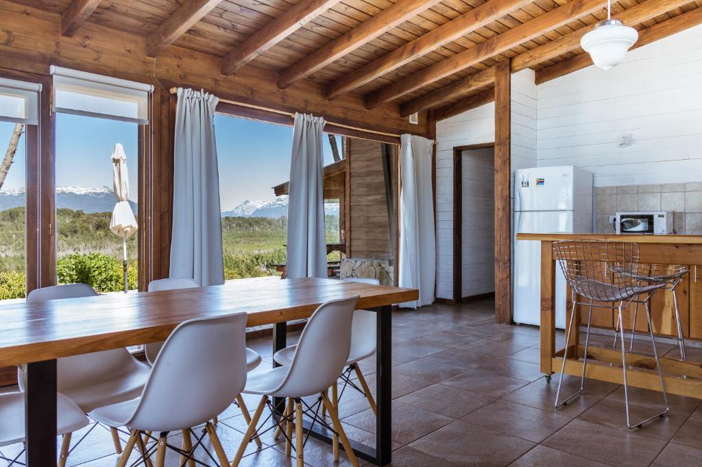 uma cozinha e sala de jantar com mesa e cadeiras em BOG Dolce Far Niente em Villa La Angostura