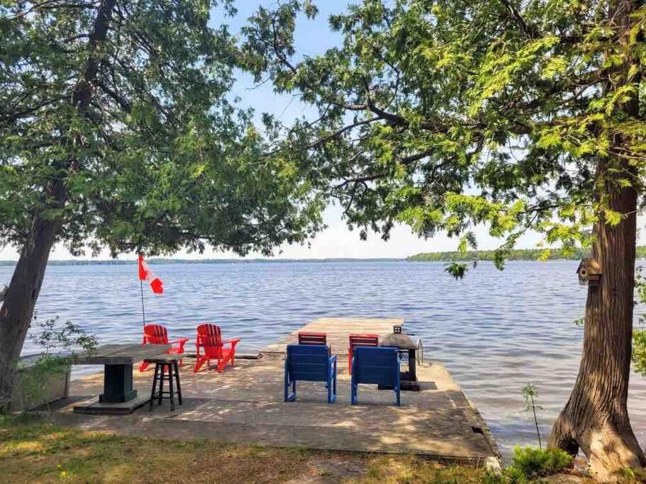 eine Anlegestelle mit Stühlen und einem Tisch auf dem Wasser in der Unterkunft Rustic Pines Waterfront Cottage *CLEAR WATER* in Fenelon Falls