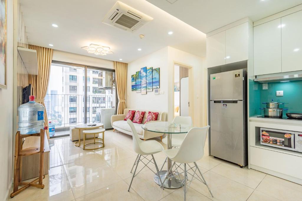 een keuken en een woonkamer met een tafel en een bank bij Vinhomes D'Capitale 2-bed apartment with Sunset view in Hanoi