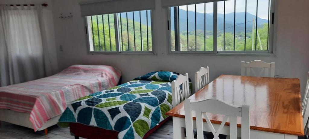 een slaapkamer met 2 bedden en een tafel en ramen bij El Despertar in Valle Hermoso